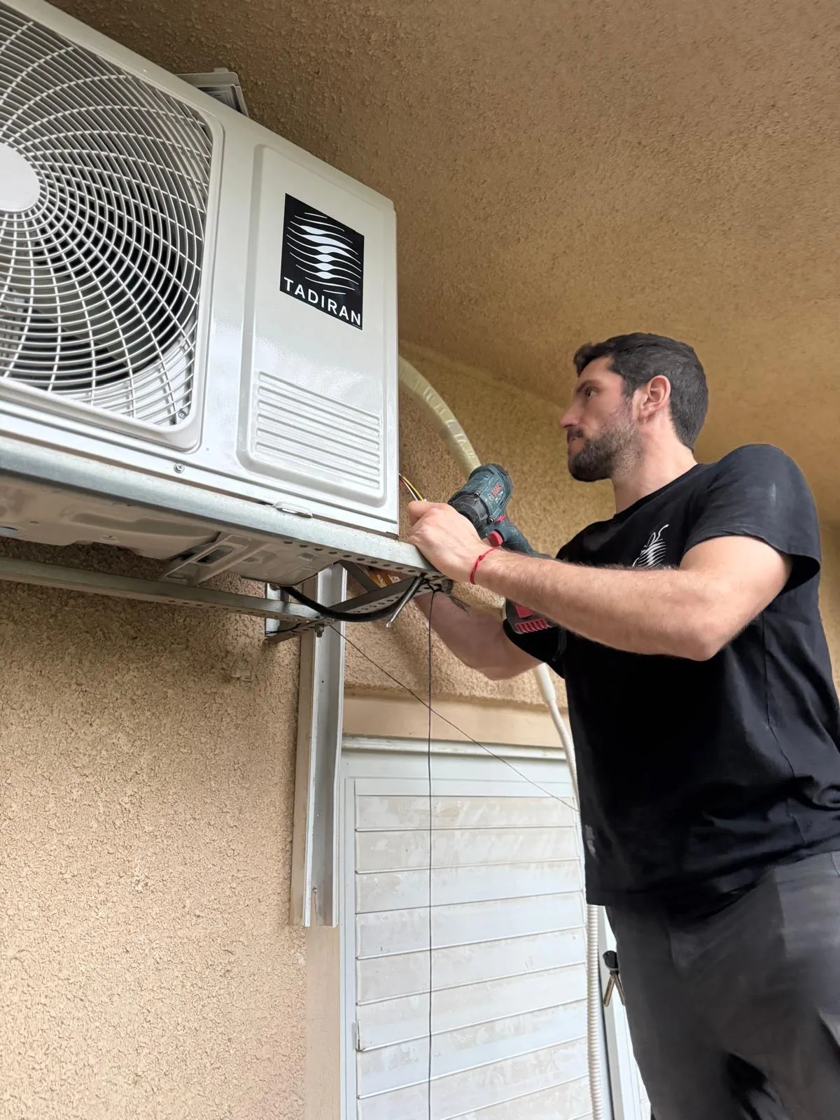 גל לוגסי מתקין יחידת מיזוג אוויר חיצונית